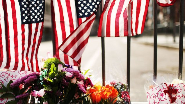 Flores são deixadas em um portão de segurança perto da cena do ataque a bomba na Maratona de Boston