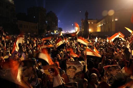Egípcios exibem a bandeira nacional e imagem do chefe militar Abdel Fatah Al-Sisi em uma das manifestações no centro do Cairo em 25 de janeiro de 2014