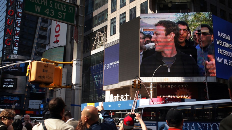 O fundador do Facebook aparece em telão em Nova York e pedestres registram momento tirando fotografias na Times Square