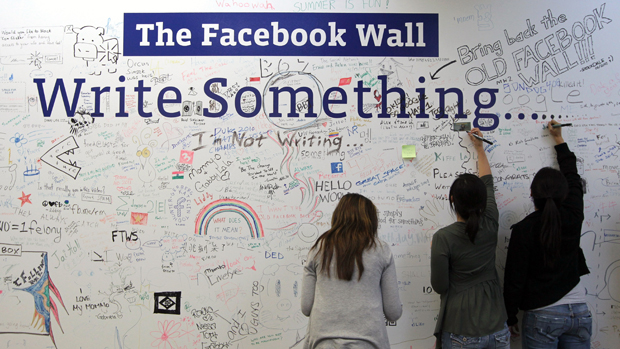 Funcionários do Facebook escrevem em um mural na sede da empresa em Palo Alto, Califórnia