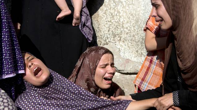 Parentes de quatro rapazes mortos em bombardeio naval israelense são vistas durante funeral na cidade de Gaza. A intensificação dos conflitos entre Israel e Palestina completam, nesta quarta-feira (16), nove dias
