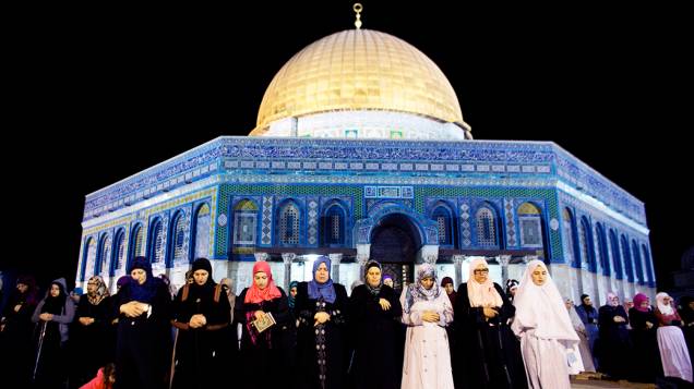Mulheres palestinas rezam em frente ao Domo da Rocha, na Cidade Velha de Jerusalém