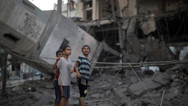Crianças palestinas obervam a destruição em uma mesquita, na cidade de Gaza, em 30/07/2014, depois que o local foi atingido por um ataque israelense durante a madrugada