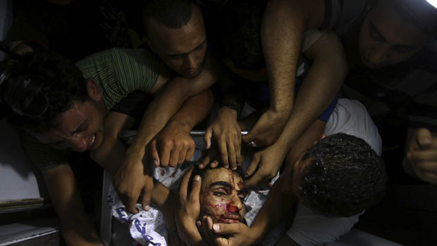 Pessoas choram em torno do corpo de um militante palestino na Faixa de Gaza, em 06/07/2014