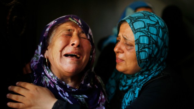 Palestinas choram durante o funeral de membros da família, na cidade de Beit Hanoun, no norte da Faixa de Gaza, em 09/07/2014