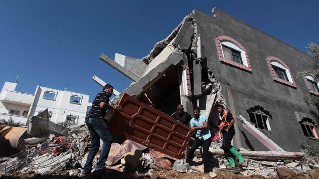 Palestinos carregam uma porta de uma casa destruída após um ataque aéreo no centro da faixa de Gaza, em 09/07/2014; Autoridades palestinas informaram que pelo menos 37 pessoas foram mortas no enclave dominado pelo Hamas