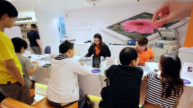Vendedoras atendem consumidores na Apple Store para a venda de Ipad3, em Cingapura