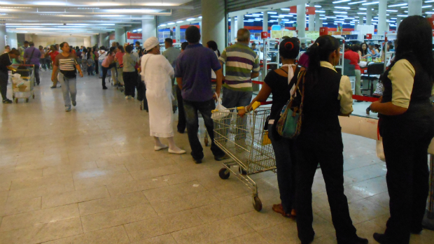 Filas enorme de venezuelanos que esperam encontrar produtos básicos em supermercado da capital Caracas