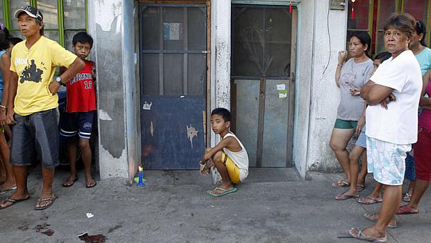 Moradores do bairro de Ronal Bae diante do local onde tiros foram disparados