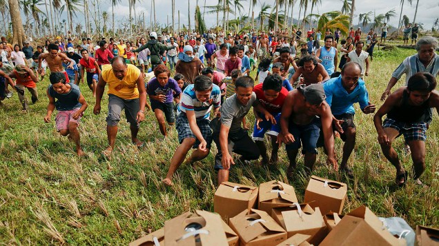 Vitimas do tufão Haiyan disputam por mantimentos entregue por helicóptero da Marinha dos EUA