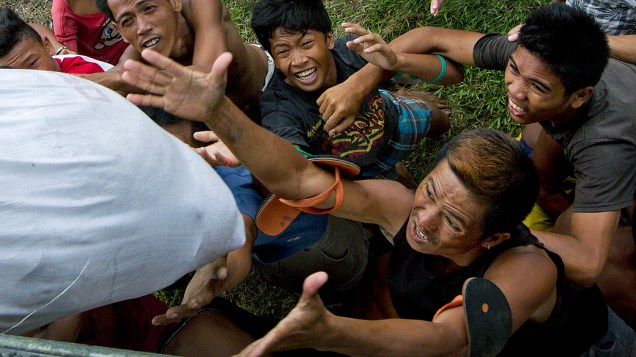 Vitimas do tufão Haiyan disputam por mantimentos entregue por helicóptero da Marinha dos EUA