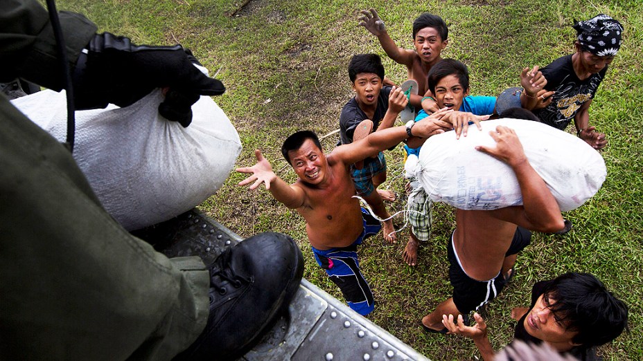 Vitimas do tufão Haiyan disputam por mantimentos entregue por helicóptero da Marinha dos EUA