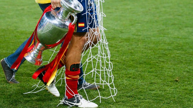 Espanhol Gerard Piqué carrega a taça e um pedaço da rede durante comemoração pelo título da Eurocopa 2012
