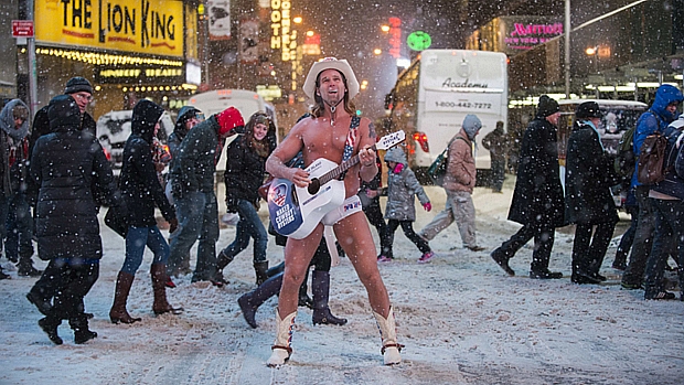 Robert Burck, conhecido como "Cowboy Nu", se apresenta embaixo de neve na Times Square, em Nova York