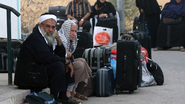 Palestinos aguardam para atravessar a fronteira com o Egito, na cidade de Rafah, em Gaza