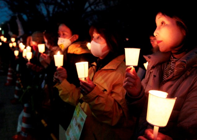 <p>Manifestantes contra o programa nuclear seguram velas e fazem corrente humana em volta do parlamento japonês, em Tóquio. O terremoto seguido de tsunami que devastou o país há um ano causou um acidente nuclear na usina de Fukushima, no nordeste do país</p>