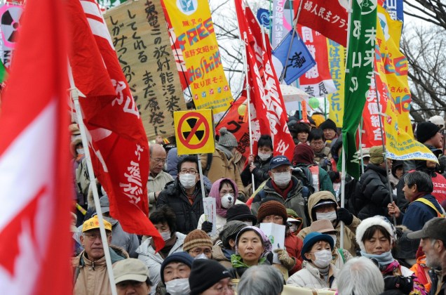 <p>Manifestantes carregam cartazes e faixas ao marcharem pelas ruas contra o programa nuclear japonês. Cerca de 16.000 pessoas fizeram parte da caminhada</p>