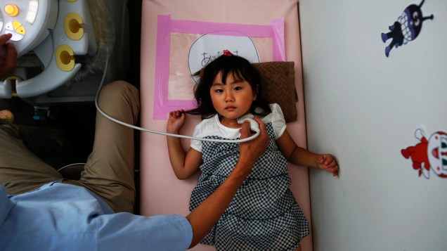 Menina faz exame de tireóide em centro de controle de radiação, na cidade de Iwaki