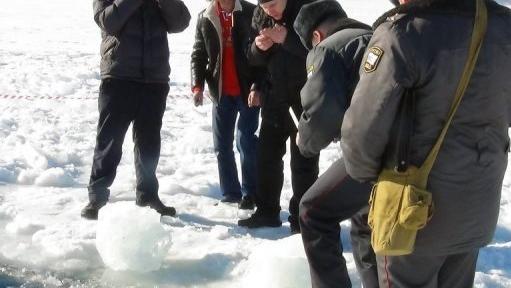 <p>Funcionários do governo observam pequenos objetos perto de lago congelado em área afetada pelo meteorito</p>