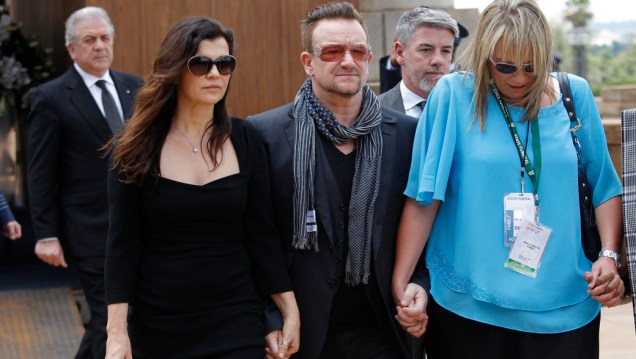 Bono Vox chega ao velório acompanhado de sua esposa, Alison Hewson, e da ex-assistente de Nelson Mandela, Zelda le Grange