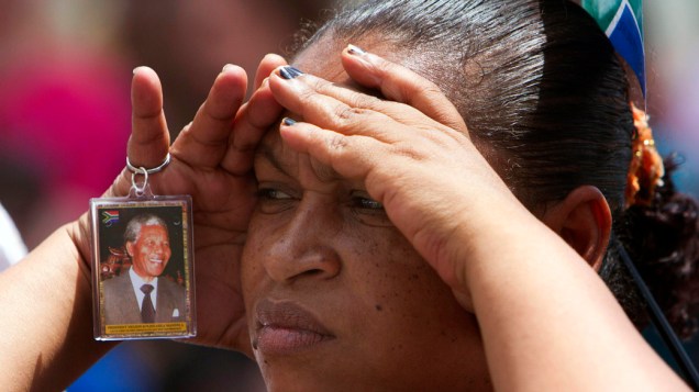 Sul-africana assiste ao funeral de Nelson Mandela em um telão