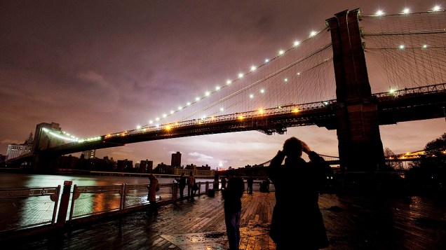 Pessoas fotografam a Ponte do Brooklyn após a passagem da tempestade Sandy