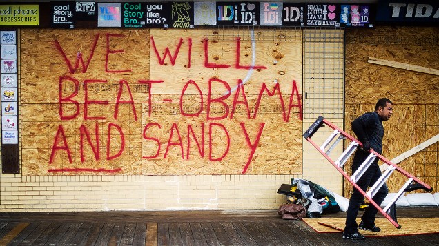 Proteção de madeira em loja de Rehoboth Beach (EUA) traz mensagem política: "Nós vamos vencer Obama e Sandy", em referência ao furacão que ameaça a região
