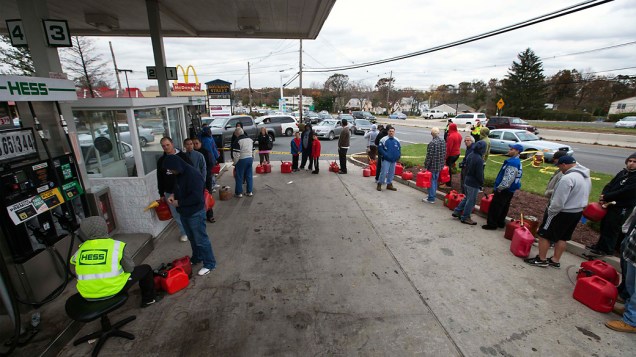 Pessoas afetadas pelas quedas de energia provocadas pela passagem do furacão Sandy fazem fila em um posto de gasolina para comprar combustível, em Madison Park, Nova Jersey