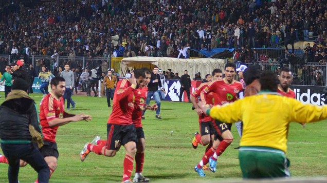 Jogadores saem do campo após torcedores invadirem o gramado durante a partida entre Al Masry e Al Ahly válida pelo Campeonato Egípcio