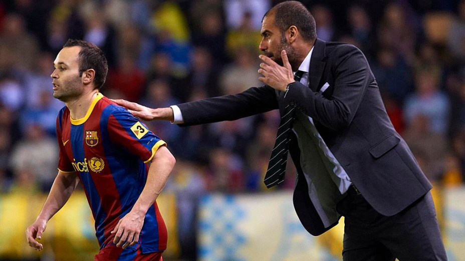 Iniesta recebe instruções de Guardiola em partida do Barcelona