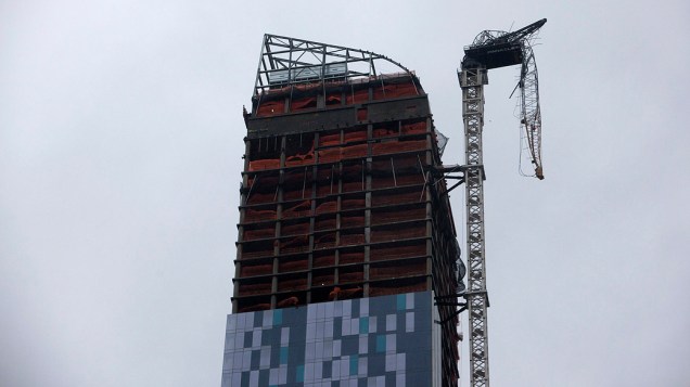 Um guindaste fica pendurado ao lado de um prédio em construção em Nova York