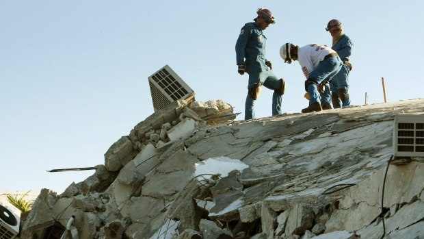 Trabalhadores realizam busca nos escombros do Hotel Montana, que ficou totalmente destruído após o terremoto que atingiu a capital do Haiti, Porto Príncipe