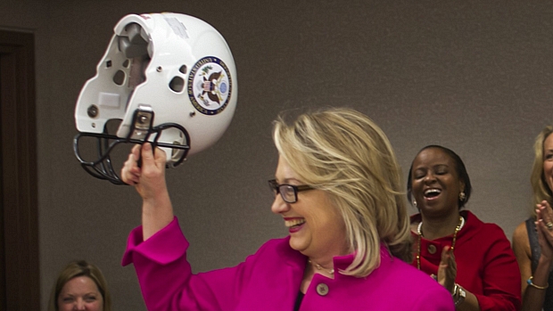 Para proteger a cabeça: Hillary exibe capacete presenteado por funcionários
