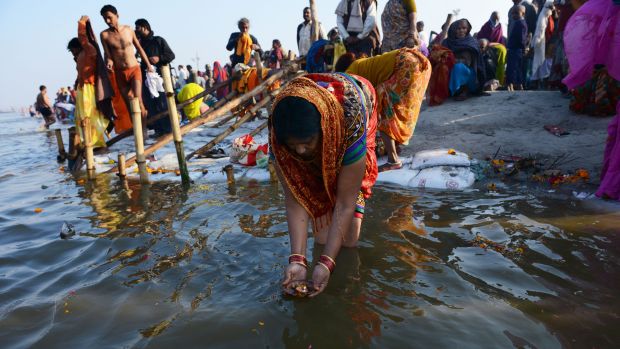 Indiana faz uma oferenda no Sangam, local de confluência dos rios sagrados Ganges, Yamuna e Saraswatu, durante o Mauni Amavasya, dia considerado mais auspicioso da celebração do Kumbh Mela, em Allahabad, na Índia