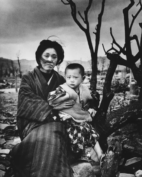 Em retrato de dezembro de 1945, mãe segura seu filho em frente à cidade de Hiroshima destruída. Eles são hibakusha, nome dado aos sobreviventes da bomba. Em contagem feita em 2008, havia 243.692 hibakusha reconhecidos oficialmente