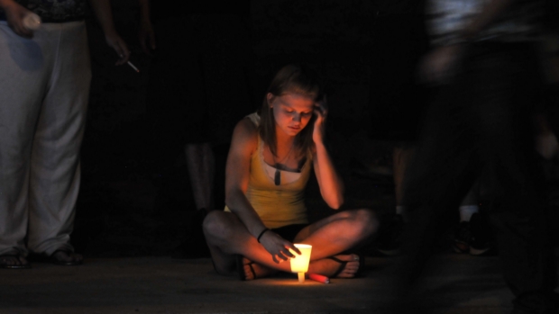 Garota acende vela em homenagem às vítimas em Aurora, nos EUA