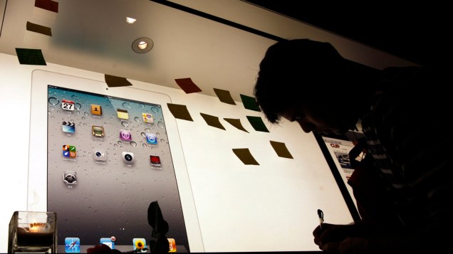 Homem escreve uma nota em homenagem a Steve Jobs em uma loja da Apple em Hong Kong, China