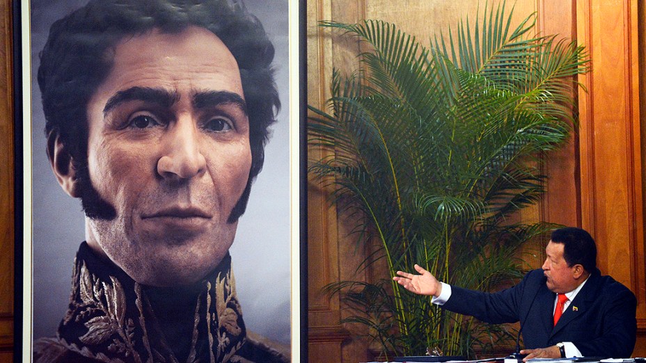 Chávez ao lado de imagem do rosto do herói da independência venezuelana, Simon Bolívar. A imagem é uma reconstrução digital a partir do crânio e do material genético do corpo de Bolívar