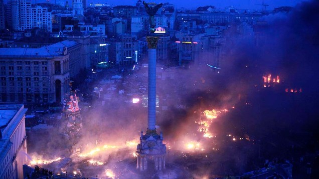 Focos de incêndio na Praça da Independência durante protestos contra o governo no centro de Kiev