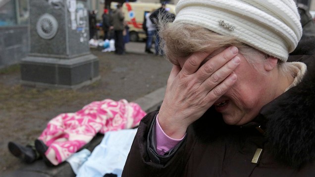 Mulher chora diante de dois corpos na na Praça da Independência, em Kiev