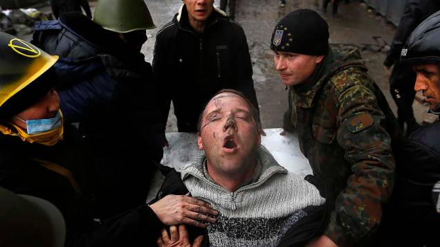 Homem ferido é socorrido em Kiev, na Ucrânia
