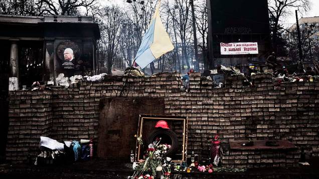 Ucranianos deixam flores em barricadas em memória dos mortos em confrontos na Praça da Independência, em Kiev, nesta terça-feira (25)
