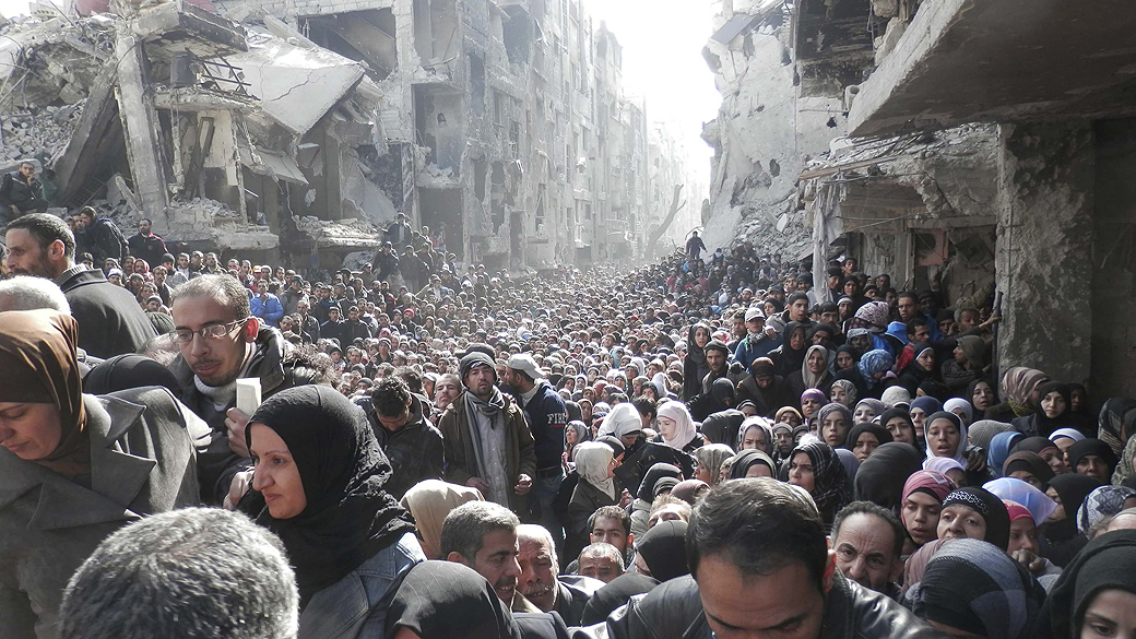 GUERRA SEM FIM: Multidão de moradores do bairro al-Yarmouk, transformado em campo de refugiados no sul de Damasco