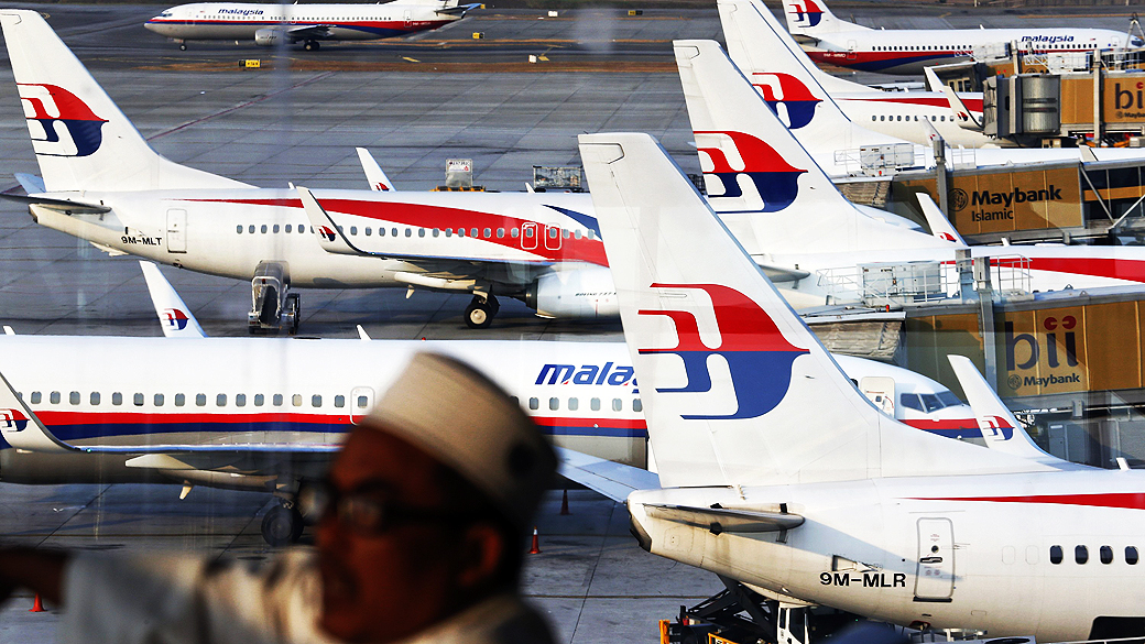 Parente de passageiro a bordo do voo MH370 da Malaysia Airlines espera por notícias no Aeroporto Internacional de Kuala Lumpur
