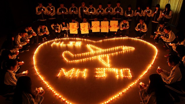 <p>Estudantes chineses acendem velas e rezam pelos passageiros do voo desaparecido da Malaysia Airlines</p>