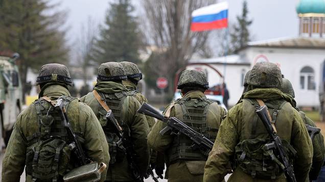 Soldados russos patrulham área circundante da unidade militar ucraniana em Perevalnoye, na região de Simferopol, Crimeia, nesta quinta-feira (20)