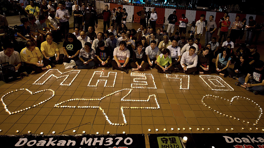 Famílias fazem orações durante vigília em praça de Kuala Lumpur, na Malásia, para marcar o aniversário de um mês do desaparecimento do jet MH370, avião da Malaysia Airlines que sumiu no Oceano Índico e até agora não foi encontrado