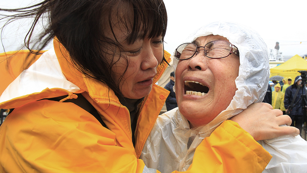 Mulher chora enquanto aguarda notícias de um familiar que estava a bordo da balsa que naufragou com 475 passageiros em Jindo, na Coreia do Sul