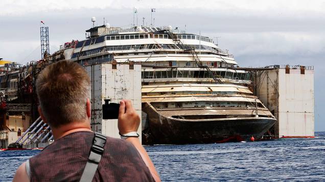 O navio de cruzeiro Costa Concordia é fotografado por turista durante operação de desencalhe, em Giglio, na Itália. Segundo informaram as autoridades, os restos da embarcação estão quase prontos para serem rebocados para longe da ilha italiana, onde atingiu uma rocha e naufragou dois anos e meio atrás, matando 32 pessoas O navio de cruzeiro Costa Concordia é fotografado por turista durante operação de desencalhe, em Giglio, na Itália. Segundo informaram as autoridades, os restos da embarcação estão quase prontos para serem rebocados para longe da ilha italiana, onde atingiu uma rocha e naufragou dois anos e meio atrás, matando 32 pessoas