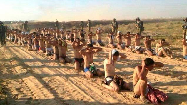 Soldados israelenses observam palestinos capturados durante uma ofensiva militar na Faixa de Gaza, em 24/07/2014